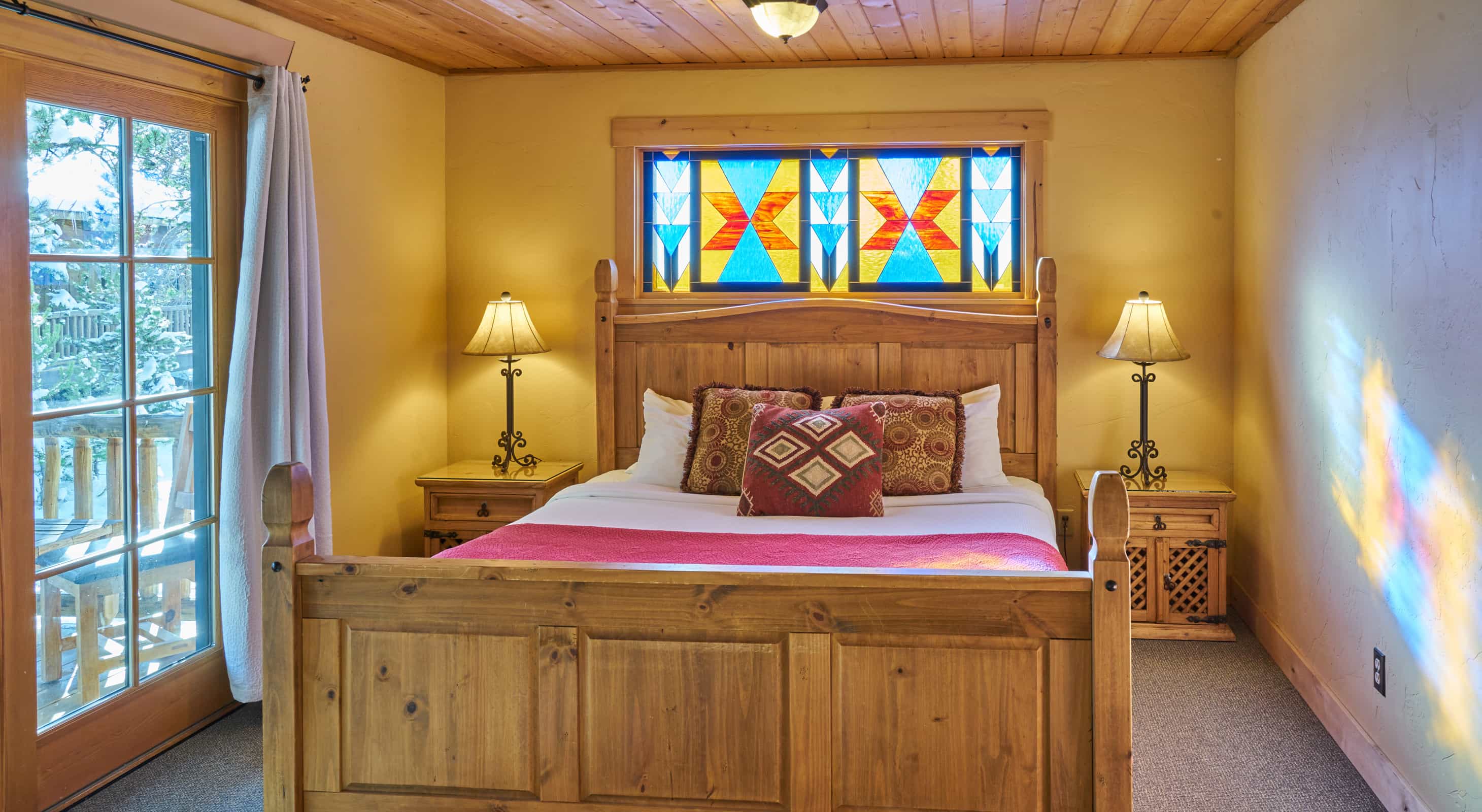 Mariposa bed with stained glass above the headboard