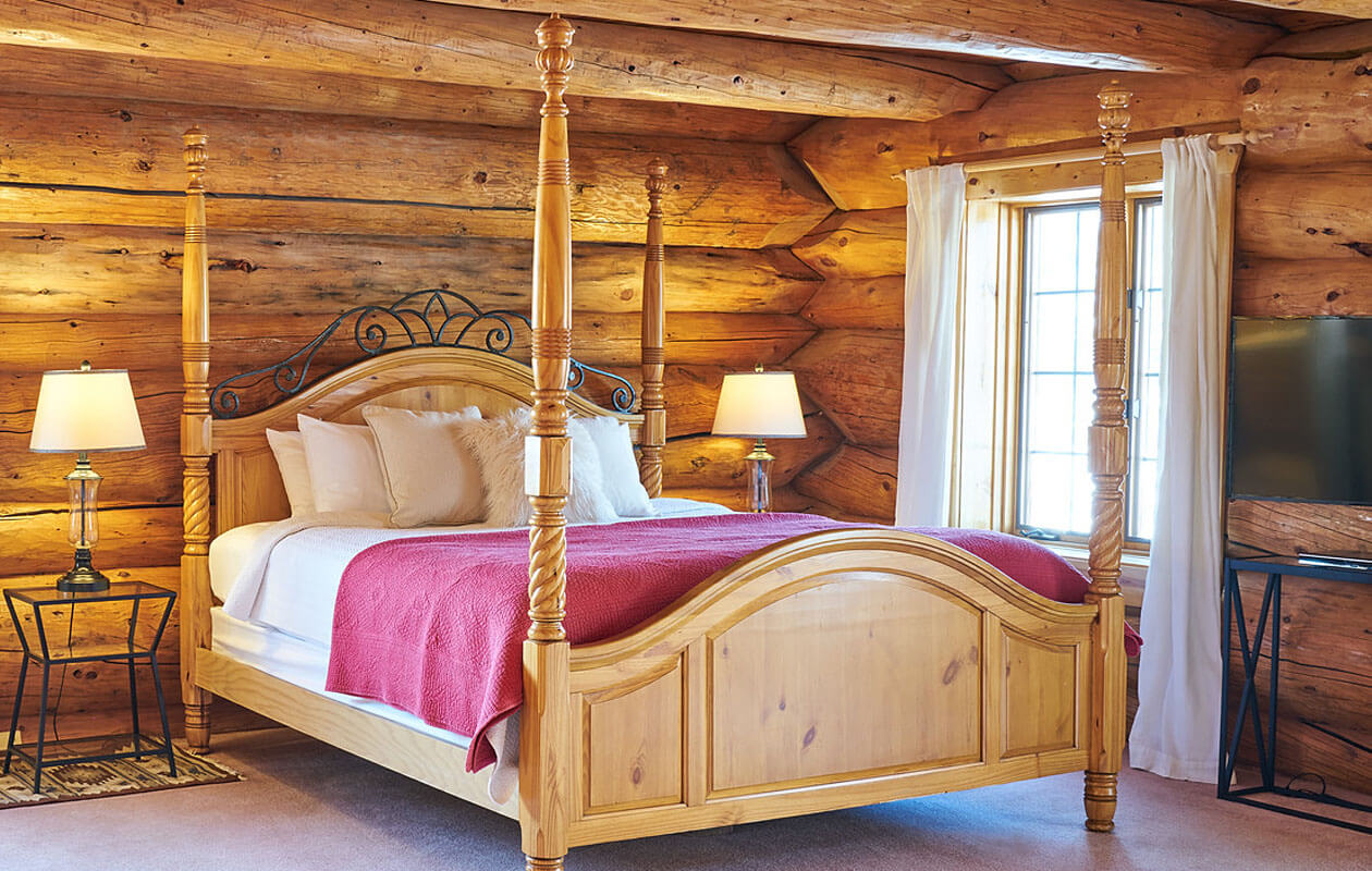log cabin room with for-poster bed